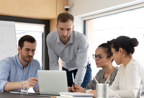 A group of people around a desk working together.